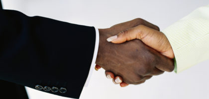 Businessman and businesswoman shaking hands, close-up