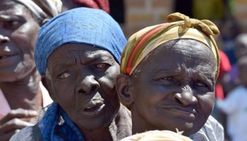 Two elderly women wait for relief food distributed by Devolution Cabinet Secretary Eugene Wamalwa and Homa Bay Woman Representative Gladys Wanga at Ndwara Primary School in West Karachuonyo on Saturday afternoon. The residents have been displaced by floods in the area. 
PHOTOS BY BARACK ODUOR